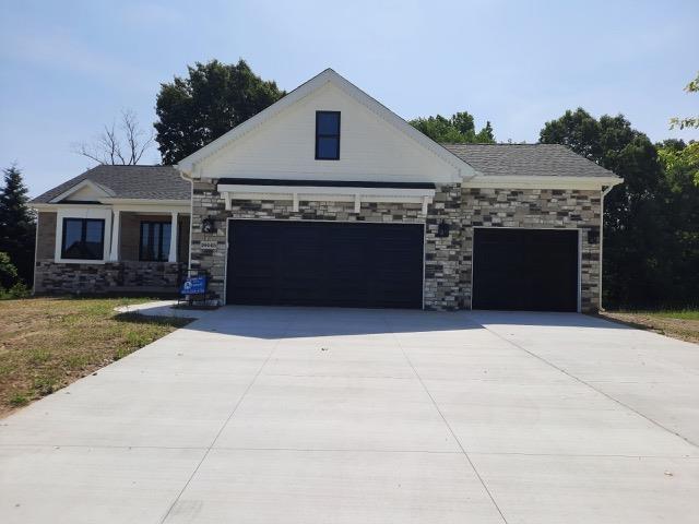 16445 Sleepy Hollow Dr, Fenton, MI 48430 - view of front of home featuring an attached garage, concrete driveway, and stone siding