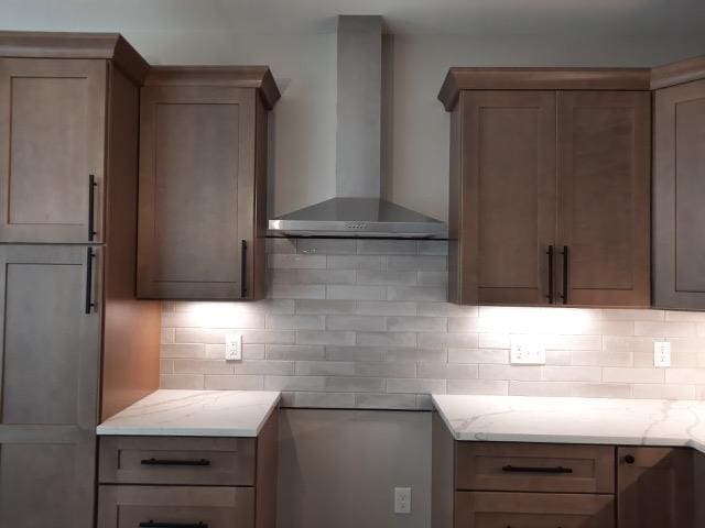 16445 Sleepy Hollow Dr, Fenton, MI 48430 - kitchen with wall chimney range hood, decorative backsplash, and light stone counters