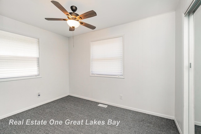 4675 E Parish Rd, Midland, MI 48642 - empty room featuring dark carpet, ceiling fan, and baseboards