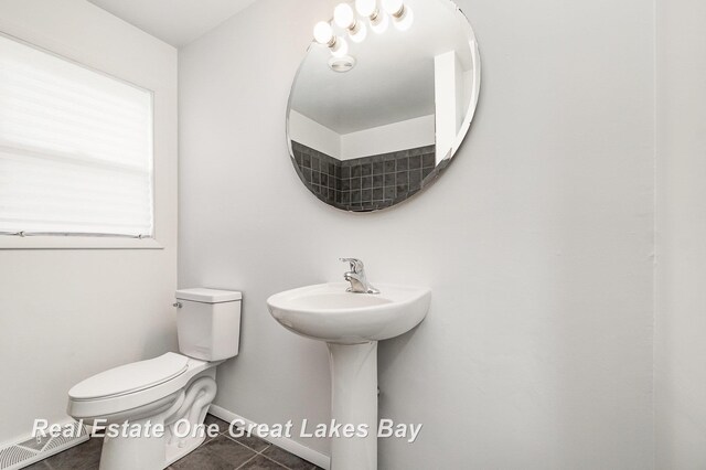 4675 E Parish Rd, Midland, MI 48642 - half bath featuring toilet, tile patterned flooring, and baseboards