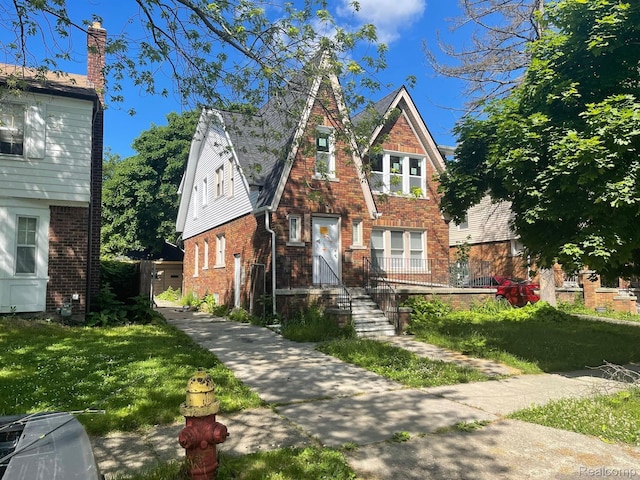 5959 Courville St, Detroit, MI 48224 - tudor home featuring brick siding and a front lawn