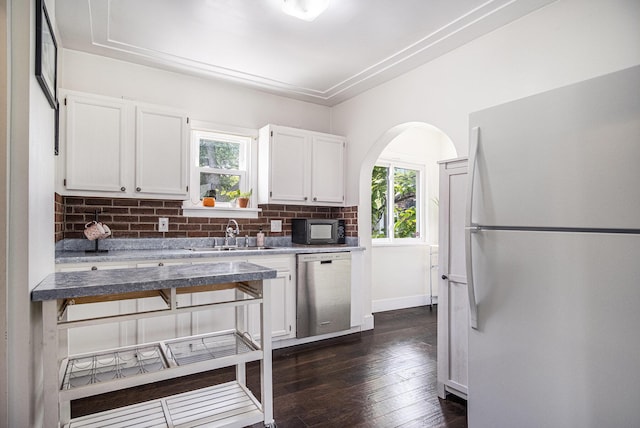 75 Diamond Ave NE, Grand Rapids, MI 49503 - kitchen with freestanding refrigerator, stainless steel dishwasher, a sink, decorative backsplash, and white cabinets