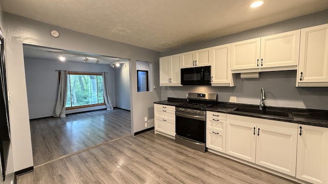 30 Zuidema Ct, Kalamazoo, MI 49001 - kitchen with stainless steel range with gas cooktop, black microwave, a sink, dark countertops, and light wood-style flooring