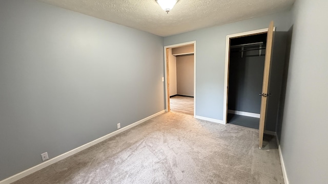 30 Zuidema Ct, Kalamazoo, MI 49001 - unfurnished bedroom with a textured ceiling, carpet, baseboards, and a closet