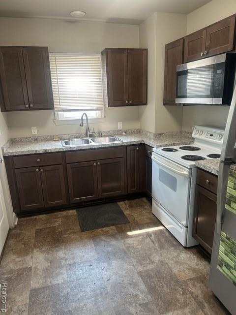 164 E Hamilton Ave, Flint, MI 48505 - kitchen with stainless steel microwave, electric stove, and dark brown cabinetry