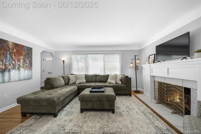 2195 Pembroke Rd, Birmingham, MI 48009 - living area featuring wood finished floors, a tiled fireplace, baseboards, and arched walkways