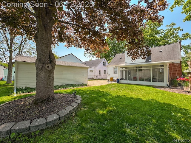 2195 Pembroke Rd, Birmingham, MI 48009 - rear view of house featuring a sunroom, a patio, and a shingled roof