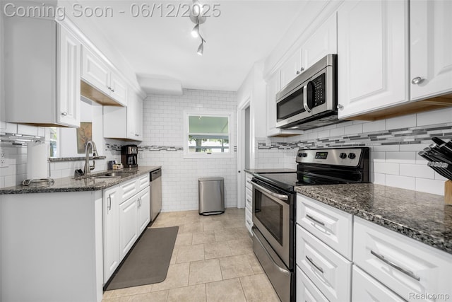 2195 Pembroke Rd, Birmingham, MI 48009 - kitchen with stainless steel appliances, a sink, white cabinets, and dark stone countertops