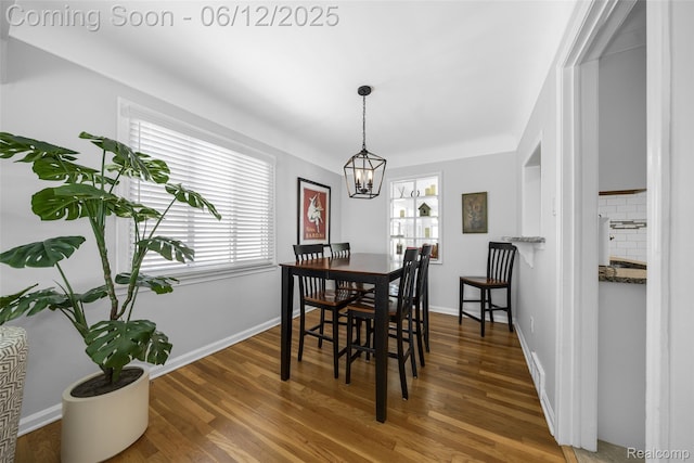 2195 Pembroke Rd, Birmingham, MI 48009 - dining space featuring wood finished floors, a chandelier, and baseboards