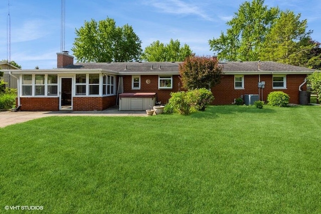 1787 Trafalgar Dr, Saint Joseph, MI 49085 - back of property featuring a hot tub, brick siding, a yard, central AC unit, and a chimney