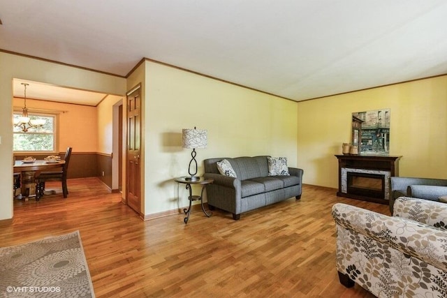1787 Trafalgar Dr, Saint Joseph, MI 49085 - living area with light wood-style floors, a chandelier, ornamental molding, a glass covered fireplace, and baseboards