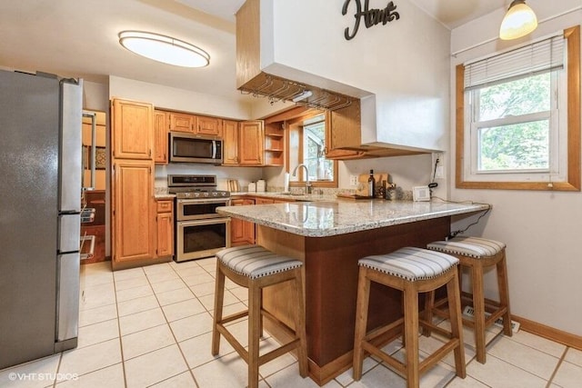 1787 Trafalgar Dr, Saint Joseph, MI 49085 - kitchen with appliances with stainless steel finishes, a peninsula, a sink, light tile patterned floors, and a kitchen bar