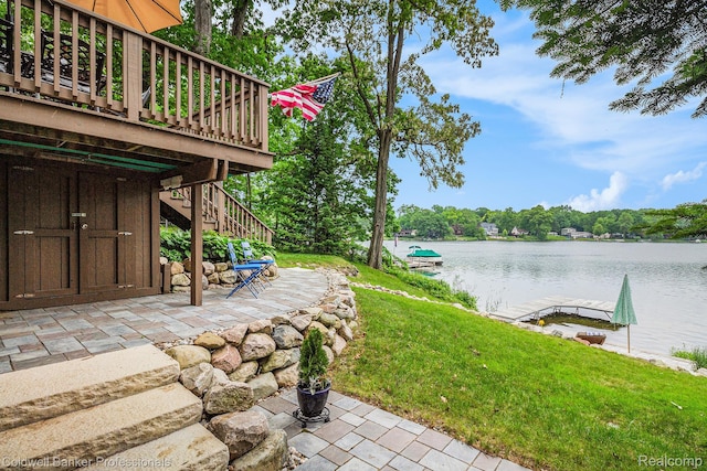1704 Clark Lake Rd, Brighton, MI 48114 - view of grassy yard with stairs, a patio, and a deck with water view