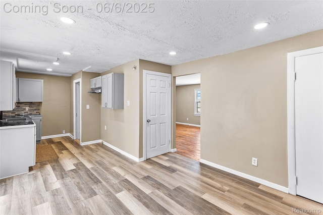 3428 Lennon Rd, Flint, MI 48507 - kitchen with recessed lighting, light wood-type flooring, baseboards, a textured ceiling, and decorative backsplash