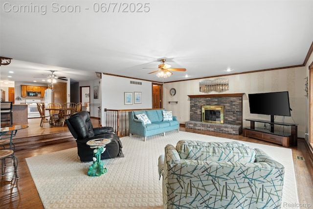 6300 Bullard Rd, Fenton, MI 48430 - living area with ceiling fan, a fireplace, wood finished floors, ornamental molding, and recessed lighting