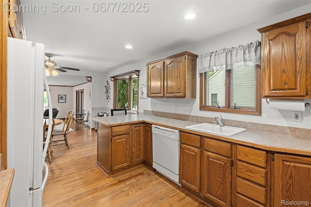 6300 Bullard Rd, Fenton, MI 48430 - kitchen with white appliances, a sink, a peninsula, brown cabinets, and light wood-style flooring