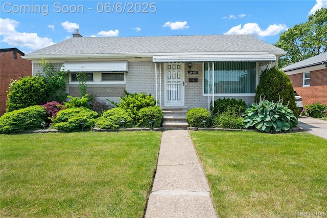 24585 Johnston Ave, Eastpointe, MI 48021 - bungalow-style house featuring brick siding, a front yard, a chimney, and roof with shingles