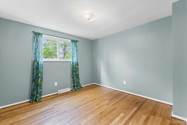 2985 Lacota Rd, Farmington, MI 48328 - spare room featuring wood finished floors and baseboards