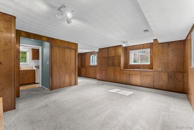 2985 Lacota Rd, Farmington, MI 48328 - unfurnished bedroom with wood walls, light colored carpet, and connected bathroom