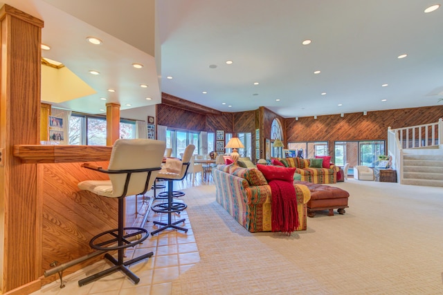 4298 Braeburn Ct, Norton Shores, MI 49441 - living room with wood walls, recessed lighting, healthy amount of natural light, a towering ceiling, and stairway
