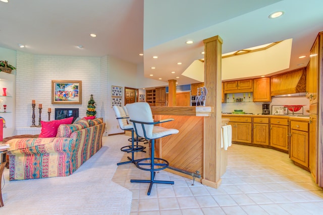 4298 Braeburn Ct, Norton Shores, MI 49441 - kitchen with recessed lighting, brown cabinetry, open floor plan, light tile patterned floors, and light countertops