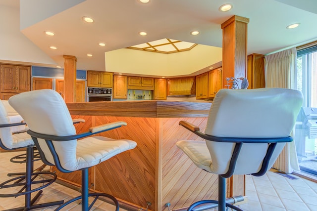 4298 Braeburn Ct, Norton Shores, MI 49441 - kitchen with oven, brown cabinetry, recessed lighting, and light tile patterned floors