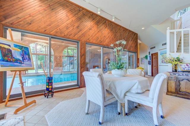4298 Braeburn Ct, Norton Shores, MI 49441 - dining area with rail lighting, vaulted ceiling, tile patterned flooring, and wooden walls