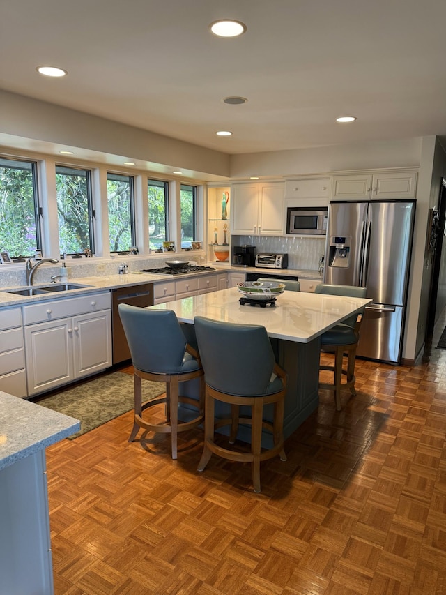 4298 Braeburn Ct, Norton Shores, MI 49441 - kitchen with appliances with stainless steel finishes, a sink, white cabinetry, tasteful backsplash, and recessed lighting