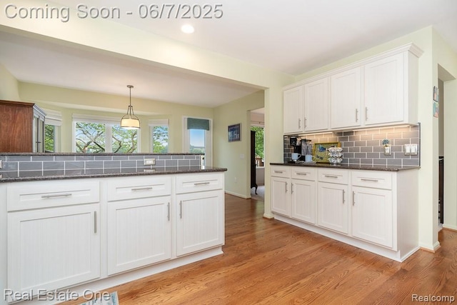 468 Orchard Ridge Dr, Lake Orion, MI 48362 - kitchen featuring white cabinets, decorative backsplash, light wood-type flooring, hanging light fixtures, and dark stone countertops