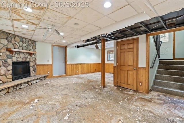 13041 Big Lake Rd, Davisburg, MI 48350 - unfurnished living room featuring a wainscoted wall, a stone fireplace, stairway, and wood walls