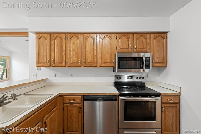 2343 Heritage Pointe Dr Unit 29, Sterling Heights, MI 48314 - kitchen featuring appliances with stainless steel finishes, a sink, brown cabinetry, and light countertops