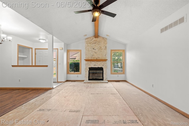 2343 Heritage Pointe Dr Unit 29, Sterling Heights, MI 48314 - unfurnished living room featuring a textured ceiling, baseboards, ceiling fan, a stone fireplace, and a chandelier