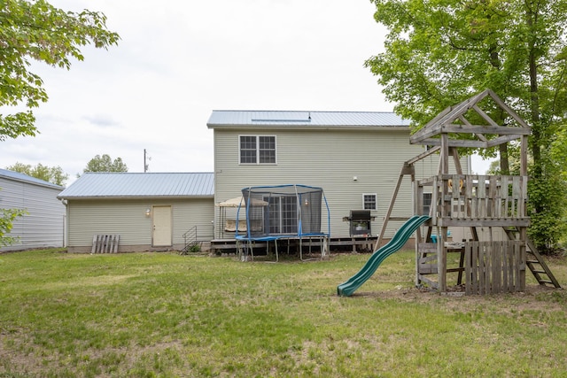 18735 Jefferson Rd, Morley, MI 49336 - back of property with a trampoline, a playground, a lawn, and metal roof