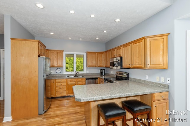 458 Amity St, Douglas, MI 49406 - kitchen with appliances with stainless steel finishes, a peninsula, recessed lighting, a sink, and light wood finished floors