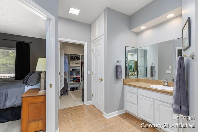 458 Amity St, Douglas, MI 49406 - ensuite bathroom featuring tile patterned flooring, vanity, baseboards, a spacious closet, and recessed lighting