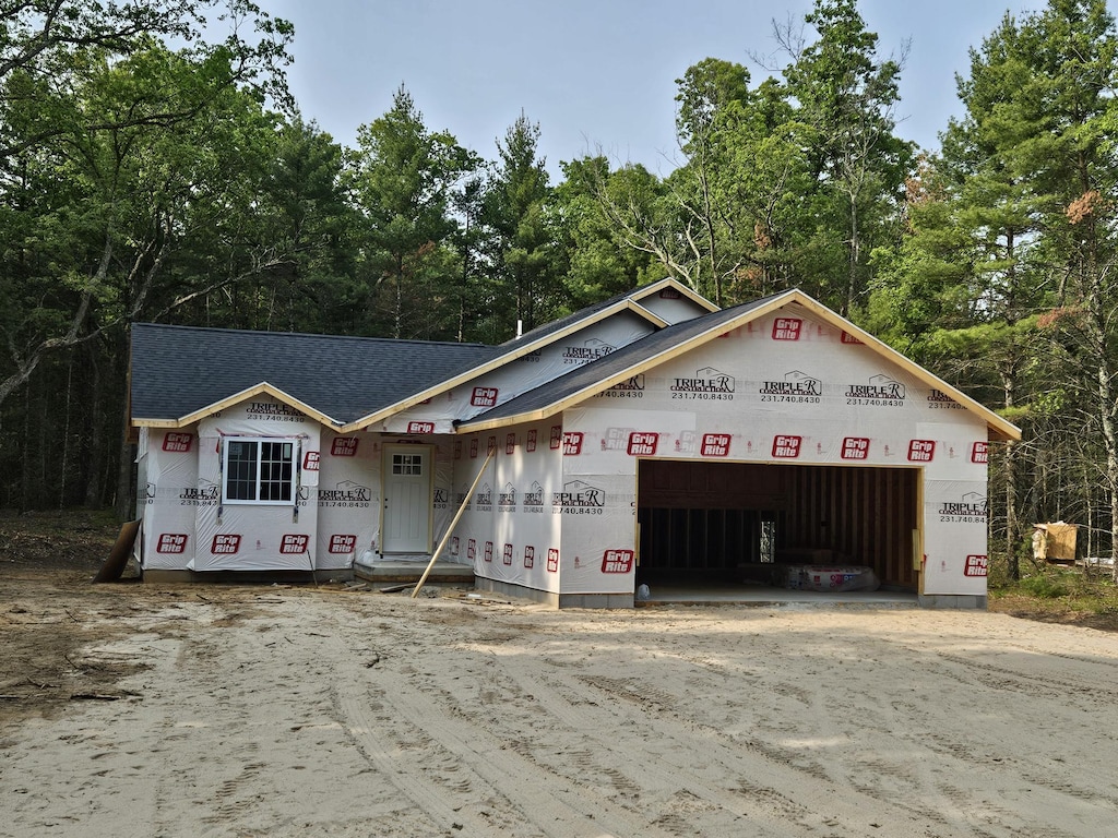 1985 E White Lake Dr, Twin Lake, MI 49457 - property under construction featuring driveway, an attached garage, and roof with shingles