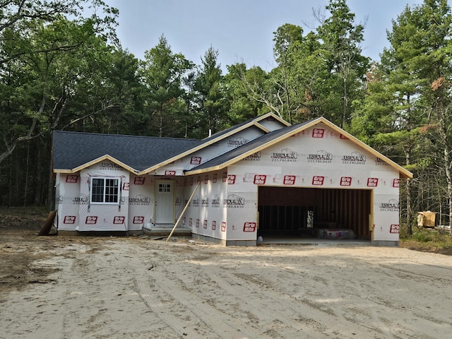1985 E White Lake Dr, Twin Lake, MI 49457 - property under construction featuring driveway, an attached garage, and roof with shingles