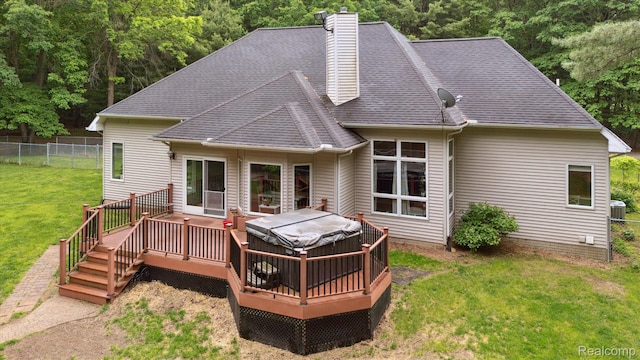 8883 Dixie Hwy, Birch Run, MI 48415 - back of house with a hot tub, a wooden deck, a chimney, and a shingled roof