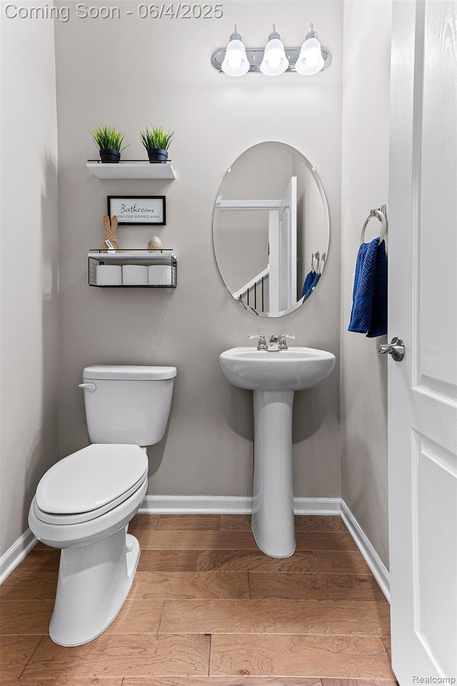 1675 Addison Cir, Walled Lake, MI 48390 - half bath with baseboards, wood finished floors, and toilet