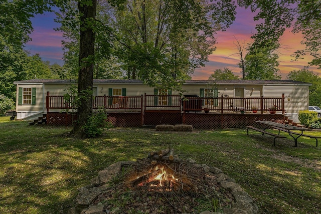 8836 Ora Lake Rd, Hale, MI 48739 - back of house featuring a fire pit, a yard, and a wooden deck