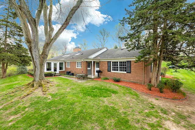 1060 Chestnut St, Ann Arbor, MI 48104 - view of front facade with a chimney, brick siding, a patio, and a front lawn