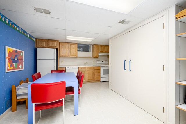 1060 Chestnut St, Ann Arbor, MI 48104 - kitchen with white appliances, under cabinet range hood, a sink, light countertops, and a drop ceiling