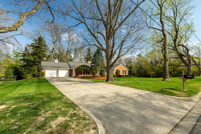1060 Chestnut St, Ann Arbor, MI 48104 - view of front of property with an attached garage, driveway, a front yard, brick siding, and a chimney