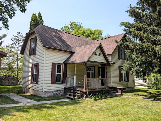 112 Howard St, Gobles, MI 49055 - view of front of house featuring a porch, roof with shingles, and a front lawn