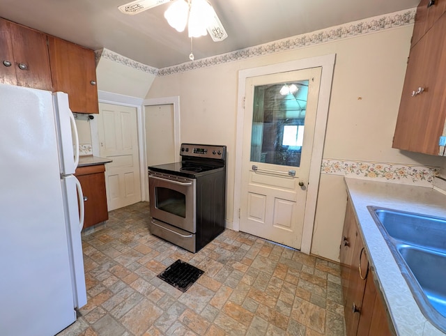 112 Howard St, Gobles, MI 49055 - kitchen featuring freestanding refrigerator, stainless steel range with electric stovetop, brown cabinets, ceiling fan, and a sink