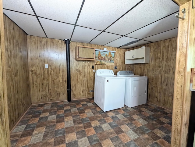112 Howard St, Gobles, MI 49055 - washroom with cabinet space, wooden walls, separate washer and dryer, baseboards, and stone finish flooring