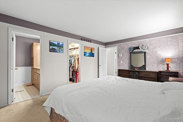7672 Admiralty Dr, Canton, MI 48187 - bedroom featuring light carpet, a spacious closet, connected bathroom, and wainscoting