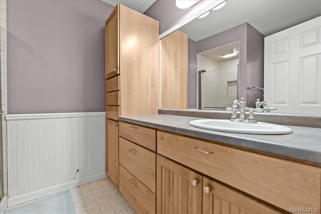 7672 Admiralty Dr, Canton, MI 48187 - bathroom featuring vanity, tiled shower, and a wainscoted wall