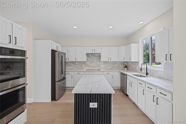 4610 Woodbine Cir W, Bloomfield, MI 48323 - kitchen featuring appliances with stainless steel finishes, a sink, under cabinet range hood, a center island, and white cabinetry