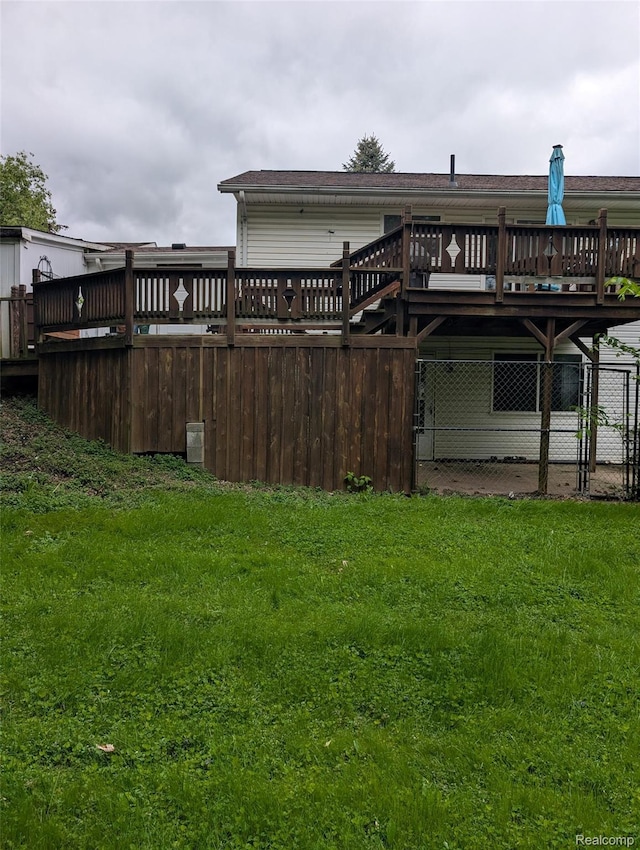 150 University Dr, Howell, MI 48843 - back of property with a wooden deck and a lawn